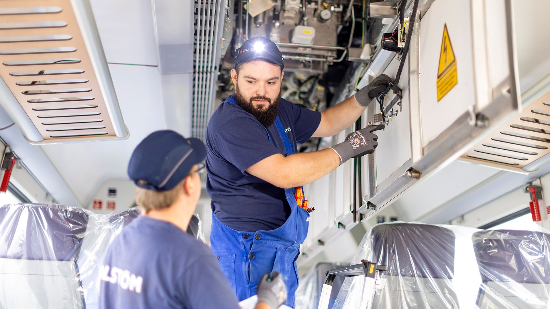 Zwei Mitarbeiter von Alstom bei Arbeiten im Zug 