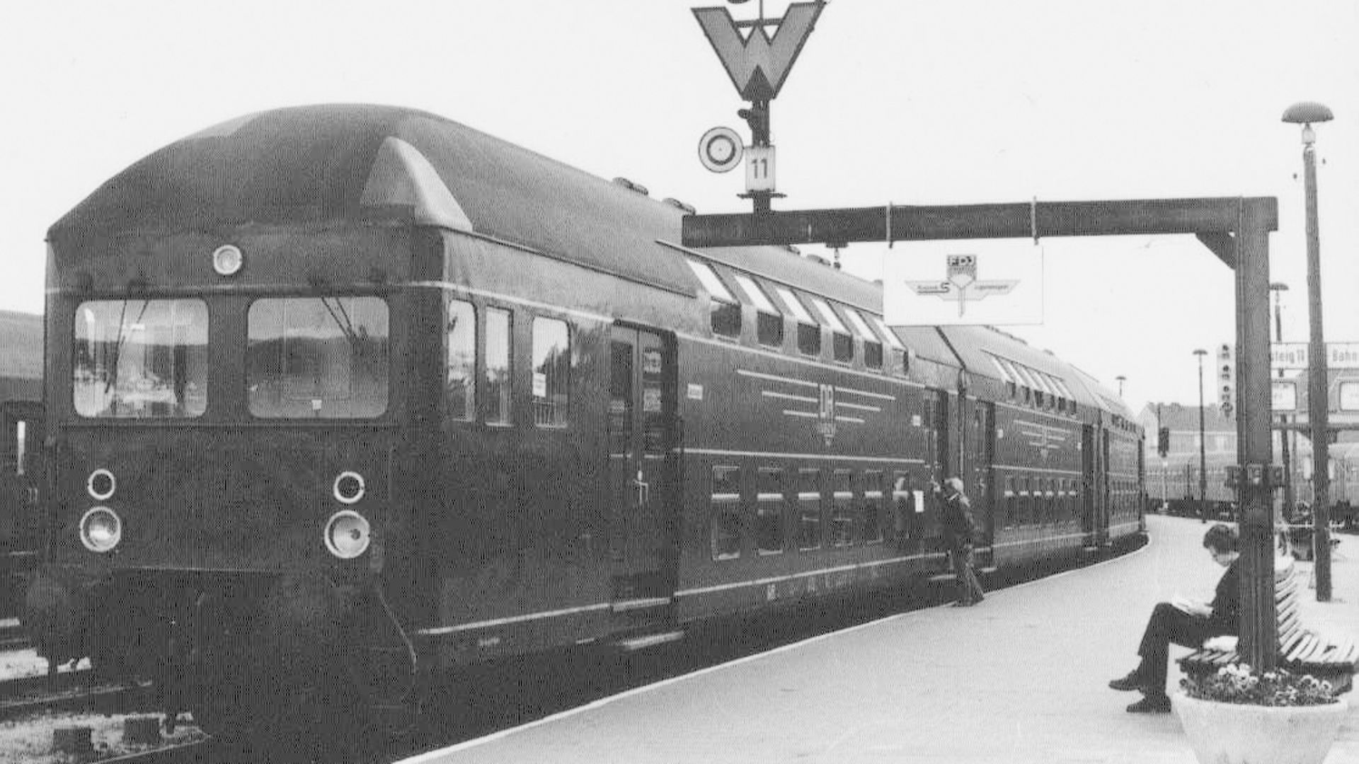 Schwarzweiß-Bild: Eine alte S-Bahn steht am Bahnhof