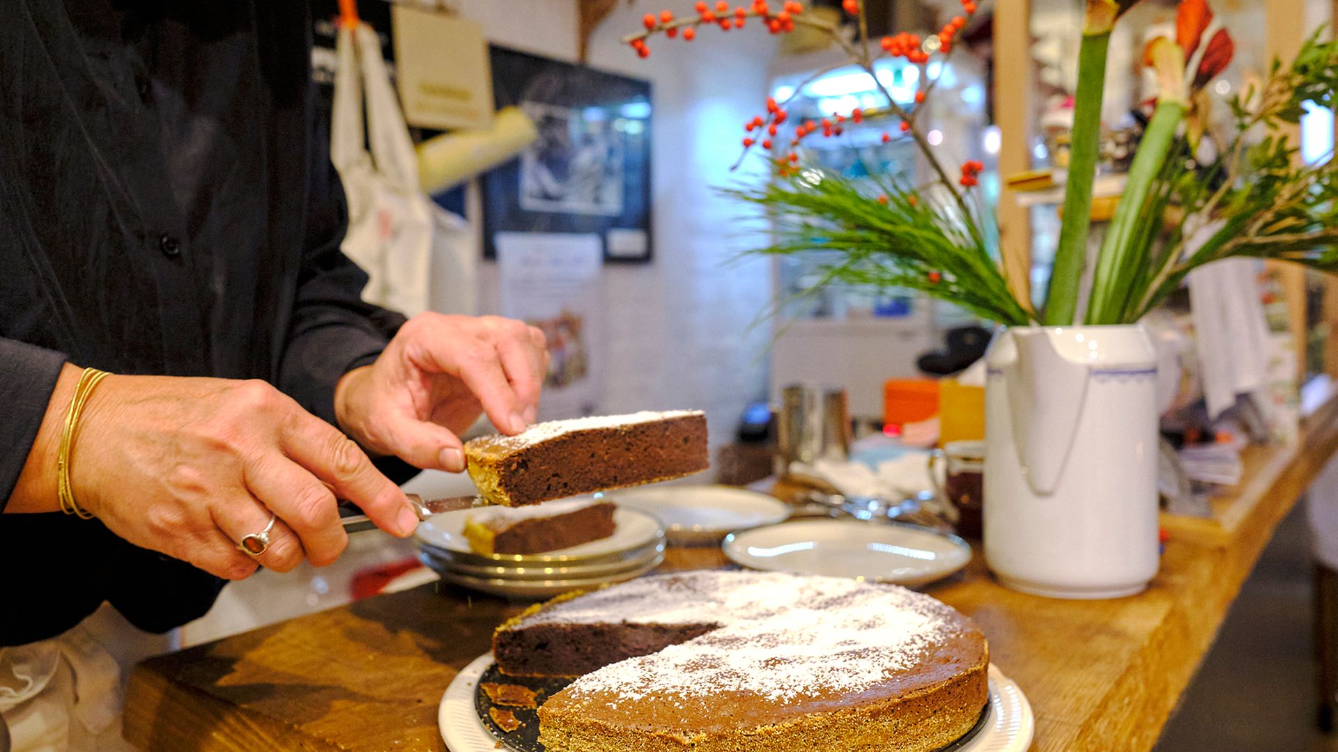 Frau schneidet im Bützower Café Stine Kuchen an, Nahaufnahme