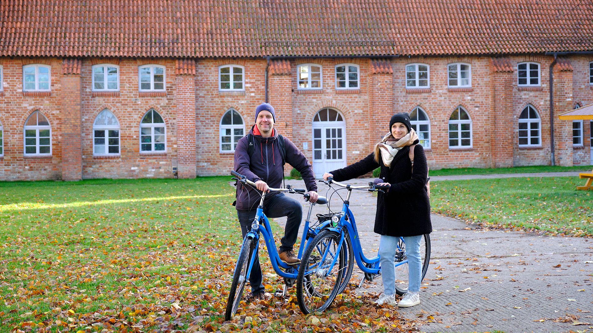 Oliver Kramer und Maike Bäßler stehen mit Rädern vor dem Kloster Rühn