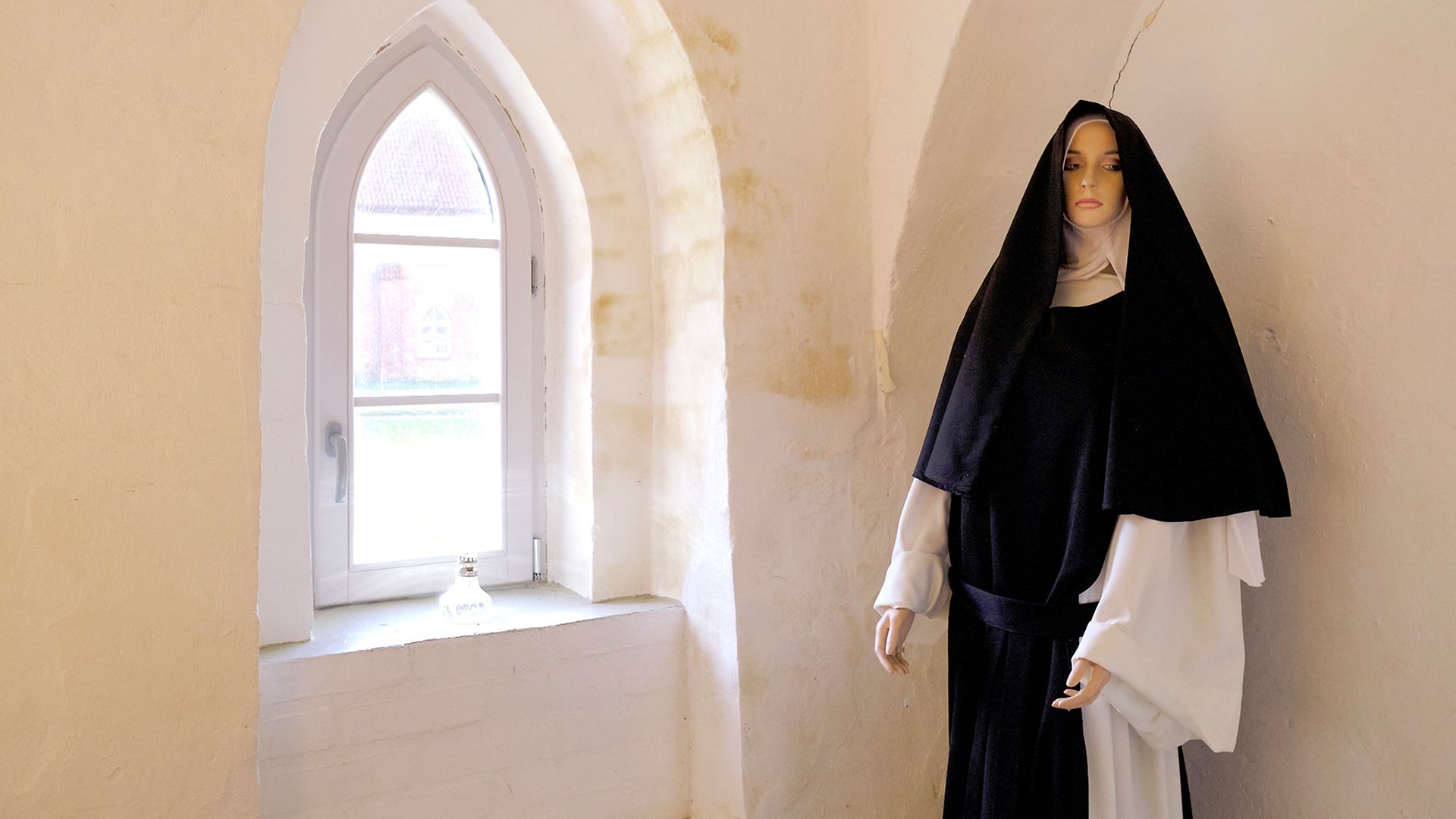 Innenansicht von Kloster Rühn mit lebensgroßer Puppe einer Nonne unter Gewölbe