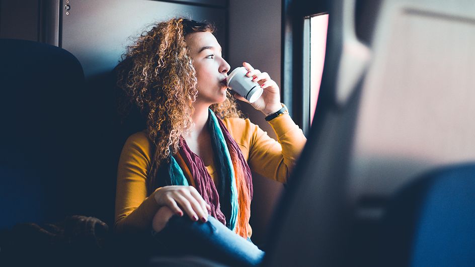 Frau in Nahaufnahme trinkt Kaffee im Zug